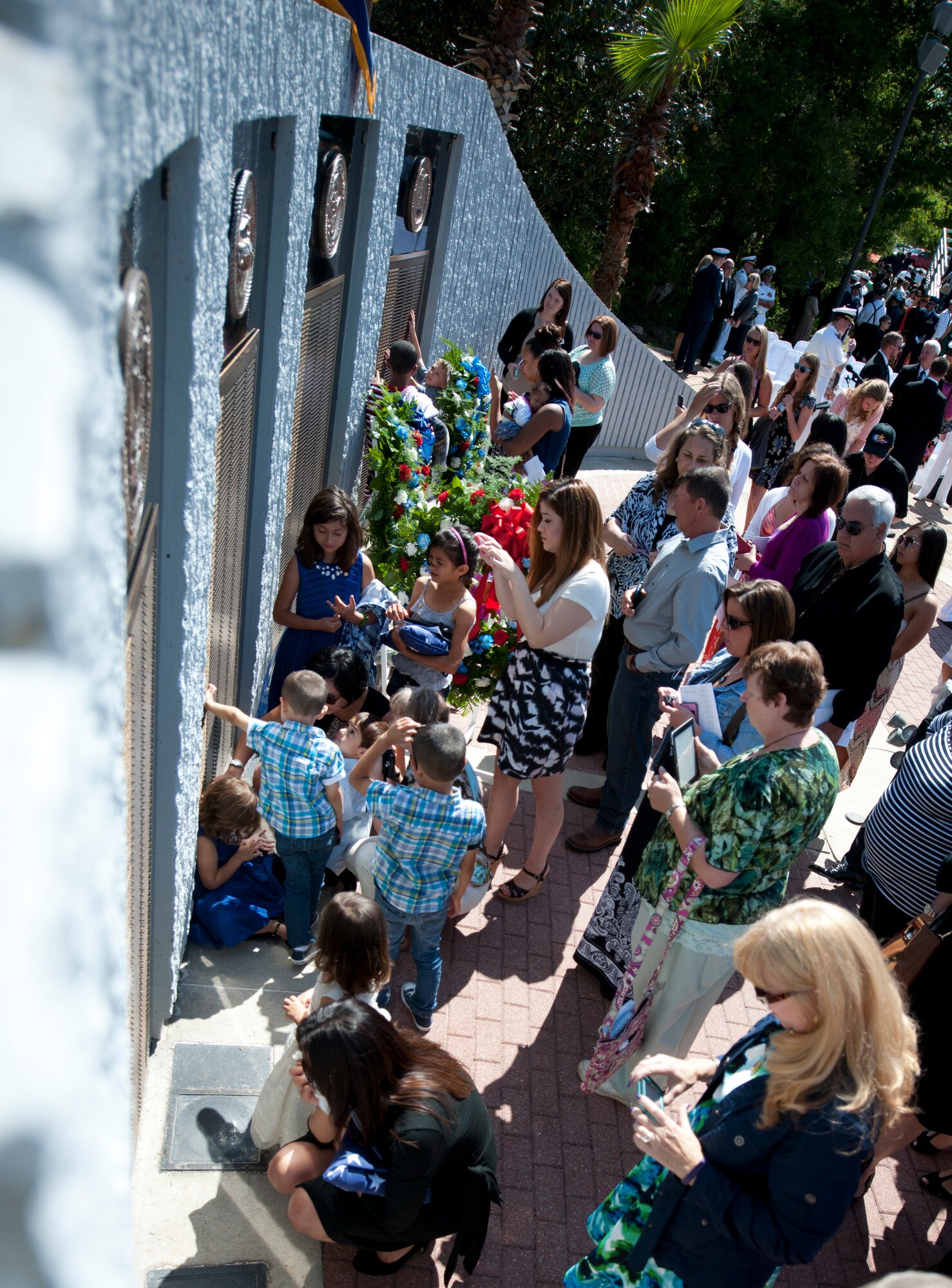 Spouses, children and families members of fallen Explosive Ordnance Disposal technicians gather at the Memorial Wall after the annual ceremony May 3 at Eglin Air Force Base, Fla. Eight new names of Army and Marine EOD technicians, who lost their lives, were added to the wall this year.  The all-service total now stands at 306. (U.S. Air Force photo/Tech. Sgt. Sam King)