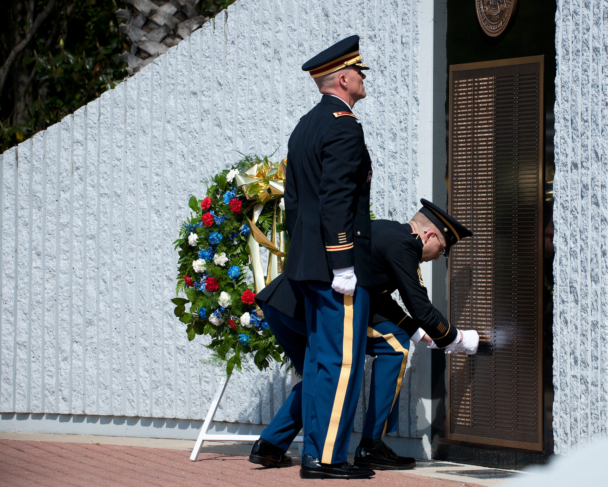 Sgt. Maj. Brian Curtis reveals a new name to the Explosive Ordnance Disposal Memorial Wall during the 45th Annual EOD Memorial Ceremony May 3, at Eglin Air Force Base, Fla. Eight new names of Army and Marine EOD technicians, who lost their lives, were added to the wall this year.  The all-service total now stands at 306. (U.S. Air Force photo/Tech. Sgt. Sam King)