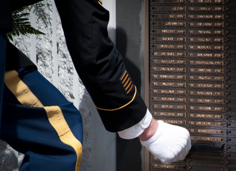 Sgt. Maj. Brian Curtis reveals a new name to the Explosive Ordnance Disposal Memorial Wall during the 45th Annual EOD Memorial Ceremony May 3, at Eglin Air Force Base, Fla. Eight new names of Army and Marine EOD technicians, who lost their lives, were added to the wall this year.  The all-service total now stands at 306. (U.S. Air Force photo/Tech. Sgt. Sam King)