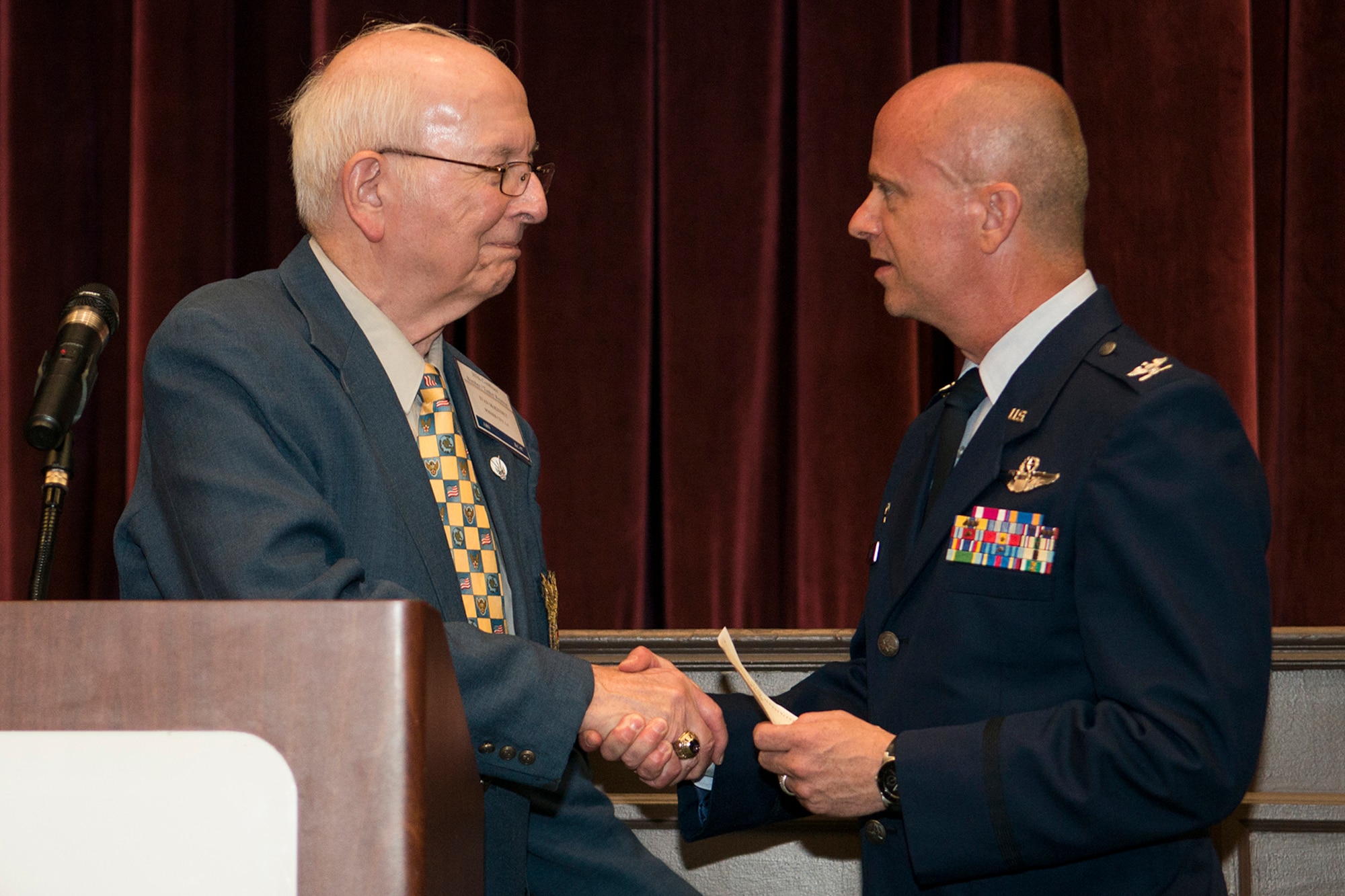 Retired U.S. Air Force Lt. Col. Ivan McKinney presents a check to Col. Jonathan Ellis, 307th Bomb Wing commander, during the 307th Combined Bomber/Tanker Reunion dinner, April 26, 2014, Bossier City, La. The 307th Air Refueling Squadron Association disbanded on Saturday of the reunion and monies left over from the treasury were donated to the successors of the historic unit to be used to maintain memorabilia of the foregone era. (U.S. Air Force photo by Master Sgt. Greg Steele/Released)