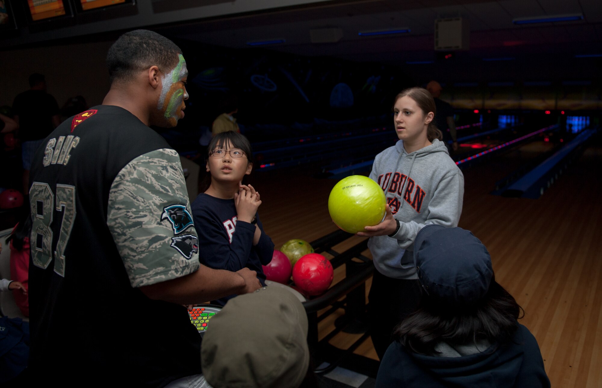 Airman 1st Class Alana Rowton, 8th Security Forces Squadron Pass and Registration journeyman, offers Staff Sgt. Perry Sinclair, 8th SFS evaluator and bowling event organizer, a “celebrity shot” at Kunsan Air Base, Republic of Korea, May 3, 2014. The squadron gave children a chance to bowl and spend time with Airmen that regularly visit the orphanage. (U.S. Air Force photo by Senior Airman Armando A. Schwier-Morales/Released)