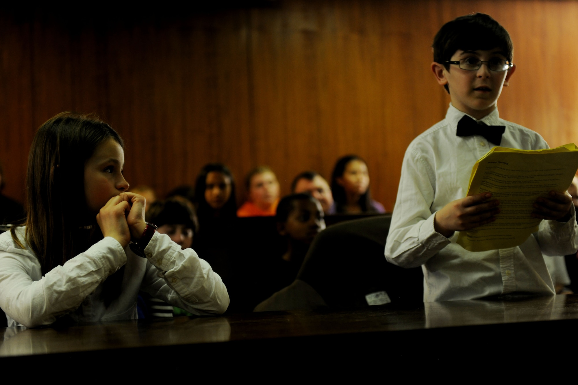 Brenna Kjorness, left, watches as her fellow prosecutor, Eli Morris, reads his opening argument during “The Trial of the Big Bad Wolf,” at RAF Alconbury, United Kingdom, May 1, 2014. Kjorness and Morris, both students at Alconbury Elementary School, played roles during the mock trial as part of the 2014 Law Day Event. (U.S. Air Force photo by Staff Sgt. Jarad A. Denton/Released)