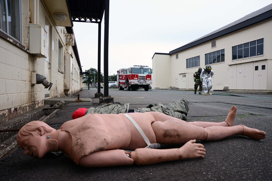 U.S. Air Force firefighters from the 35th Civil Engineer Squadron approach a simulated hangar fire near two simulated casualties at Misawa Air Base, Japan, May 5, 2014. The scenario is part of a week-long Operational Readiness Exercise which tests the 35th Fighter Wing's preparedness during wartime scenarios. (U.S. Air Force photo/Senior Airman Derek VanHorn)