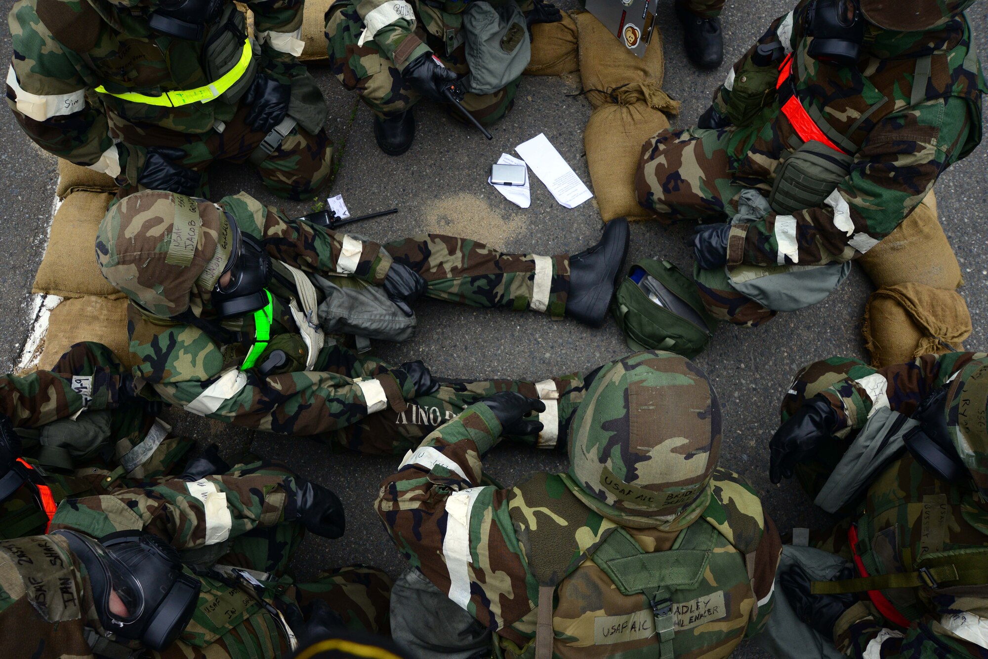U.S. Air Force Airmen from the 35th Fighter Wing gather together in a designated bunker area after being flushed from their hangar due to a fire during an Operational Readiness Exercise at Misawa Air Base, Japan, May 5, 2014. Following simulated attacks during the week-long exercise, Airmen respond at a real-world pace, retreating to bunkers and performing self-aid buddy care to injured Airmen. (U.S. Air Force photo/Senior Airman Derek VanHorn)