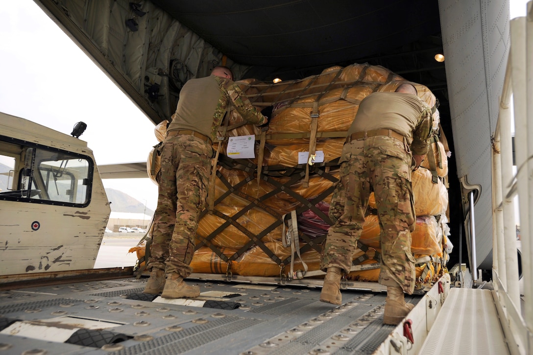 U.S. service members load a pallet of humanitarian aid onto a C-130 aircraft at Kabul International Airport, Afghanistan, May 4, 2014, to be flown and delivered to Badakshan province, to support disaster relief efforts.