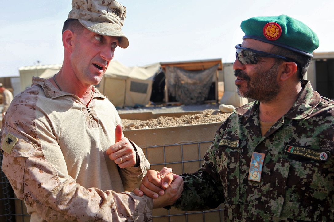 U.S. Marine Corps Col. Christopher Douglas, left, wishes Afghan National army Brig. Gen. Zamarai Khan Tarz the best of luck before leading his team out of Forward Operating Base Nolay in Afghanistan's Helmand province, to Camp Leatherneck, May 3, 2014. Douglas is team leader for the 2nd Brigade, 215th Corps, Afghan National Army.