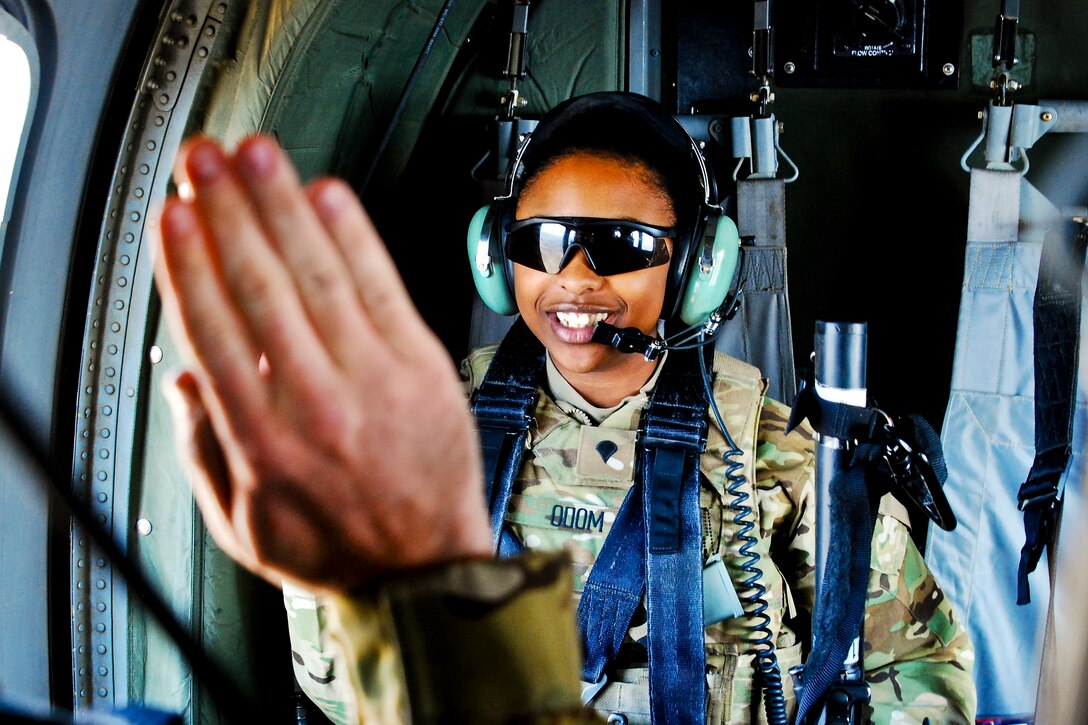 U.S. Army Spc. Joy Odom recites the oath to re-enlist from the back of a UH-60L Black Hawk helicopter during a mission over Laghman province, Afghanistan, Nov. 1, 2013. Odom, an aviation operations specialist, is assigned to Headquarters Company, 10th Combat Aviation Brigade.  