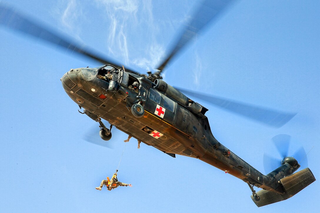 A U.S. Army UH-60 Black Hawk helicopter hoists an Australian airman during medevac training on Multinational Base Tarin Kot in Afghanistan's Uruzgan province, Oct. 13, 2013. The helicopter crew is assigned to Company C, 2nd Battalion, 1st General Support Aviation Battalion.  