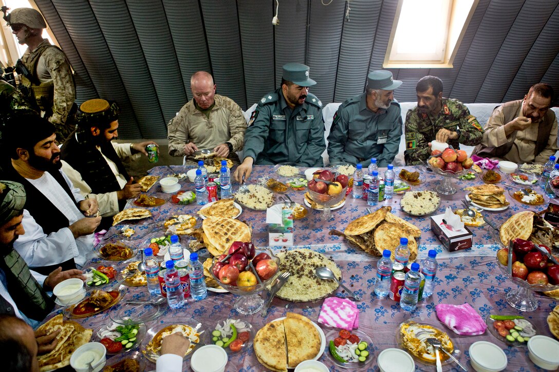 Leaders from coalition and Afghan security forces eat lunch together at the Afghan border police headquarters in Lashkar Gah in Afghanistan's Helmand province, Oct. 8, 2013. U.S Marine Corps Maj. Gen. Walter L. Miller Jr., commanding general of Regional Command Southwest, and other staff members traveled to the police headquarters to attend a promotion ceremony. The coalition forces are assigned to the regional command.  