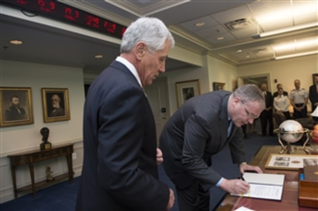 Defense Secretary Chuck Hagel, left, swears in new Deputy Defense Secretary Bob Work at the Pentagon, May 5, 2014. 