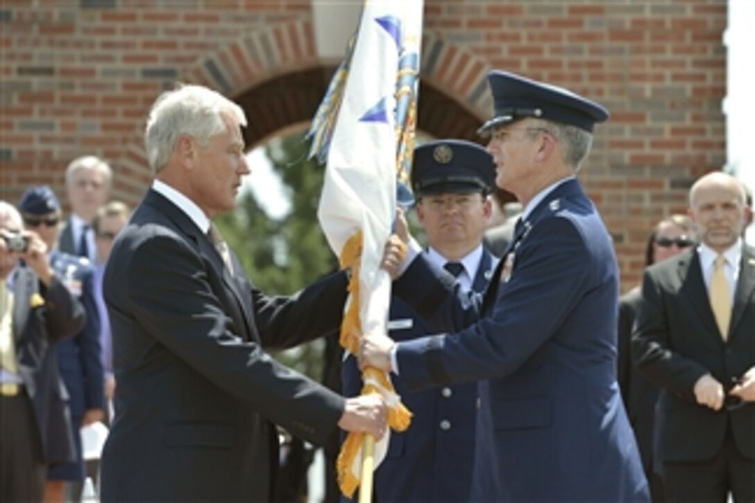 Defense Secretary Chuck Hagel passes the command flag to Air Force Gen. Paul J. Selva, the incoming commander of U.S. Transportation Command, during the change-of-command ceremony on Scott Air Force Base, Ill., May 5, 2014. Selva relieves Air Force Gen. William M. Fraser III, the outgoing commander, who retired after 40 years of service.