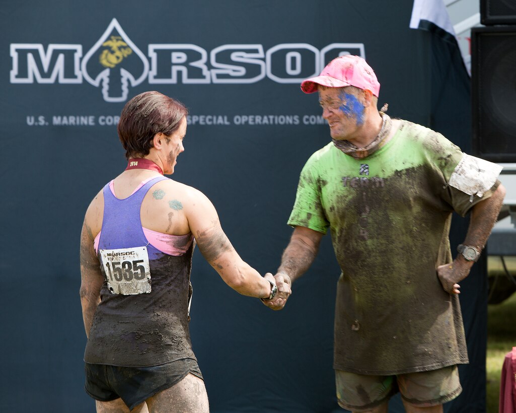 Major Gen. Mark A. Clark, commanding general of U.S. Marine Corps Forces Special Operations Command, congratulates Staff Sgt. Sheena Stevens, MARSOC G-7 Air Chief, as she receives her finishing medal for completing the muddy and murky 5-mile MARSOC Mud, Sweat and Tears run at Stone Bay aboard Marine Corps Base Camp Lejeune, N.C., April 26.  The MARSOC mud run provides MARSOC the opportunity to connect with the local community and build camaraderie amongst the Marines at MCB Camp Lejeune. This year’s mud run held a special significance as the families of some of MARSOC’s fallen Marines and sailors ran in the race, following ‘Honor the Fallen,’ a one-of-a-kind event, the day prior that honored all Marines, sailors and civilian Marines lost at home and abroad since MARSOC’s inception. (Official U.S. Marine Corps photo by Sgt. Scott Achtemeier)