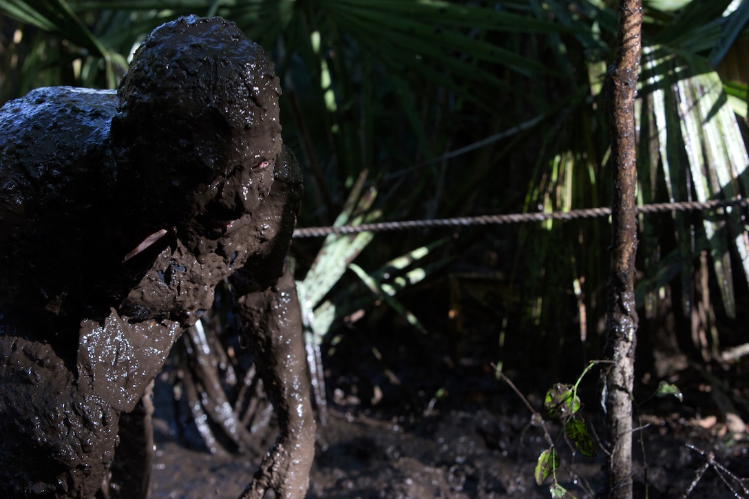 A participant crawls his way out of a mud pit during the muddy and murky 5-mile MARSOC Mud, Sweat and Tears run at Stone Bay aboard Marine Corps Base Camp Lejeune, N.C., April 26.  The MARSOC mud run is annual event, and provides MARSOC the opportunity to connect with the local community and build camaraderie amongst the Marines at MCB Camp Lejeune. This year’s mud run held a special significance as the families of some of MARSOC’s fallen Marines and sailors ran in the race, following ‘Honor the Fallen,’ a one-of-a-kind event, the day prior that honored all Marines, sailors and civilian Marines lost at home and abroad since MARSOC’s inception. 
