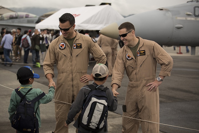Capt. Brian Hall, left, and Capt. Ted Lindell, right, shake hands with Japanese boys, after posing for a photo in front of an F/A-18, during Friendship Day at Marine Corps Air Station Iwakuni, Japan, May 5, 2014. Hall and Lindell are aviators with Marine Attack Squadron 224, currently stationed at MCAS Iwakuni under the Unit Deployment Program. Friendship Day is an event that allows Japanese citizens a chance to see military vehicles and aircraft, meet American service members and get a taste of American culture.