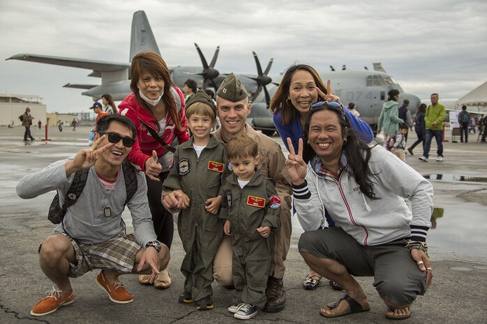 Capt. Matthew Sisneros, center, and his children, Adam and Max, pose with patrons during Friendship Day aboard Marine Corps Air Station Iwakuni, Japan, May 5, 2014. Sisneros is an aviator with Marine All Weather Fighter Attack Squadron 242. Friendship Day is an event that allows Japanese citizens a chance to see military vehicles and aircraft, meet American service members and get a taste of American culture.