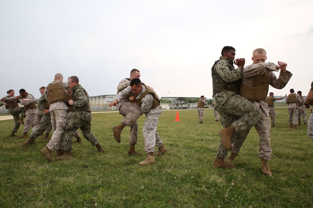 Marines and sailors execute Marine Corps Martial Arts Program techniques May 1 at Marine Corps Air Station Futenma during a battalion super squad competition. Super squad is a physically demanding competition that builds teamwork and unit cohesion. The Marines and sailors are with Headquarters and Service Battalion, Marine Corps Base Camp Smedley D. Butler, Marine Corps Installations Pacific