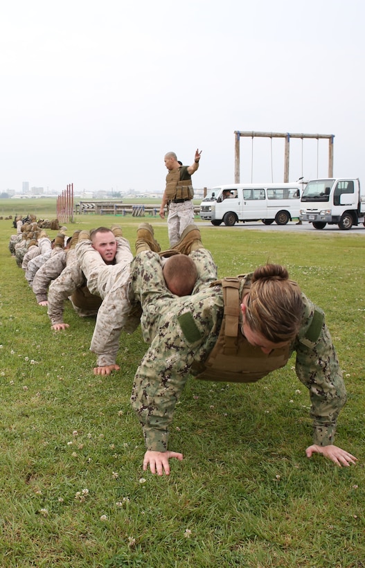 Marines and sailors execute squad pushups May 1 during a battalion super squad competition at Marine Corps Air Station Futenma. Super squad competitors need to work as a team to successfully complete physically demanding challenges. The Marines and sailors are with Headquarters and Service Battalion, Marine Corps Base Camp Smedley D. Butler, Marine Corps Installations Pacific. 