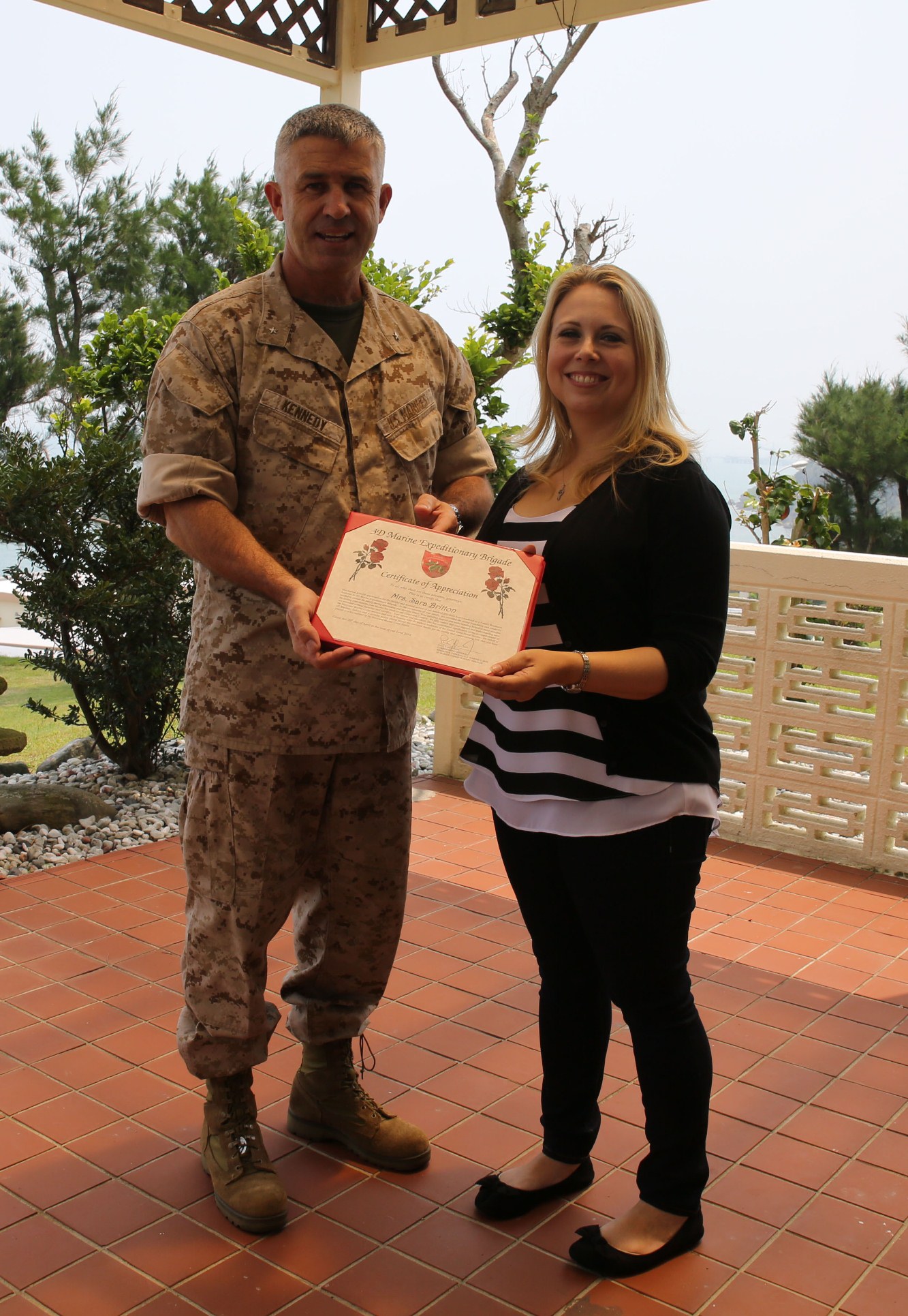 Brig. Gen. Paul J. Kennedy, left, presents Sara Britton with a certificate of appreciation for her dedicated work as a family readiness assistant for 3rd Marine Expeditionary Brigade April 30 at Camp Courtney. As a family readiness assistant, Britton served 153 hours, working hand-in-hand with the family readiness officer to assist service members and families of 3rd MEB, III Marine Expeditionary Force. Britton is a Portland, Maine native. Kennedy is the commanding general of 3rd MEB. 