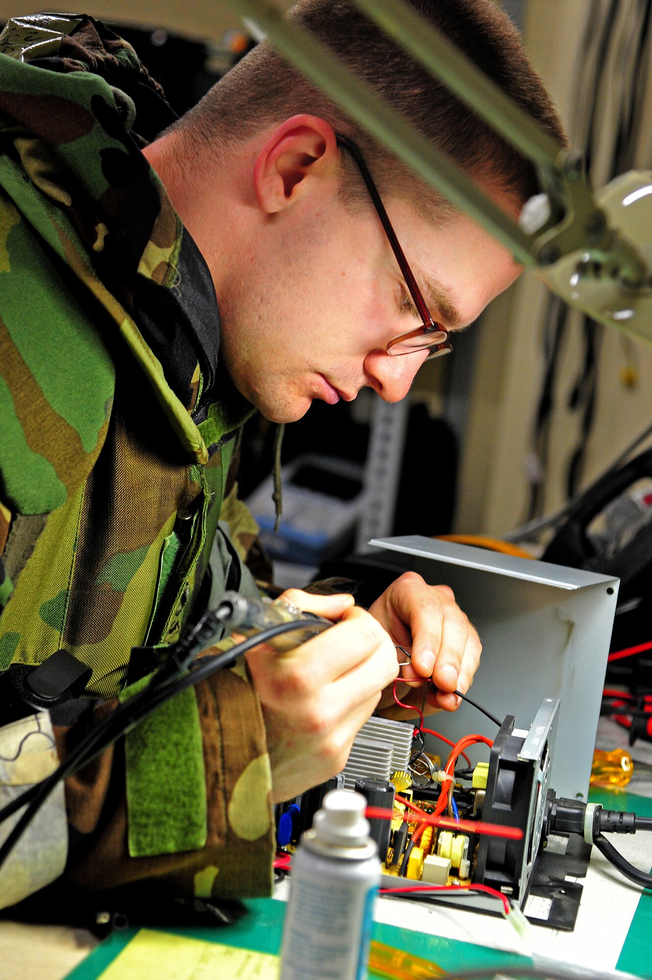 U.S. Air Force Airman 1st Class Andrew Woods, 35th Communications Squadron client systems technician, solders wires on the power supply of a base system at Misawa Air Base, Japan, May 7, 2014. When any of the base's mobile communication equipment breaks down, Woods and his team troubleshoot and fix the problem. (U.S. Air Force photo/Senior Airman Jose Hernandez-Domitilo)