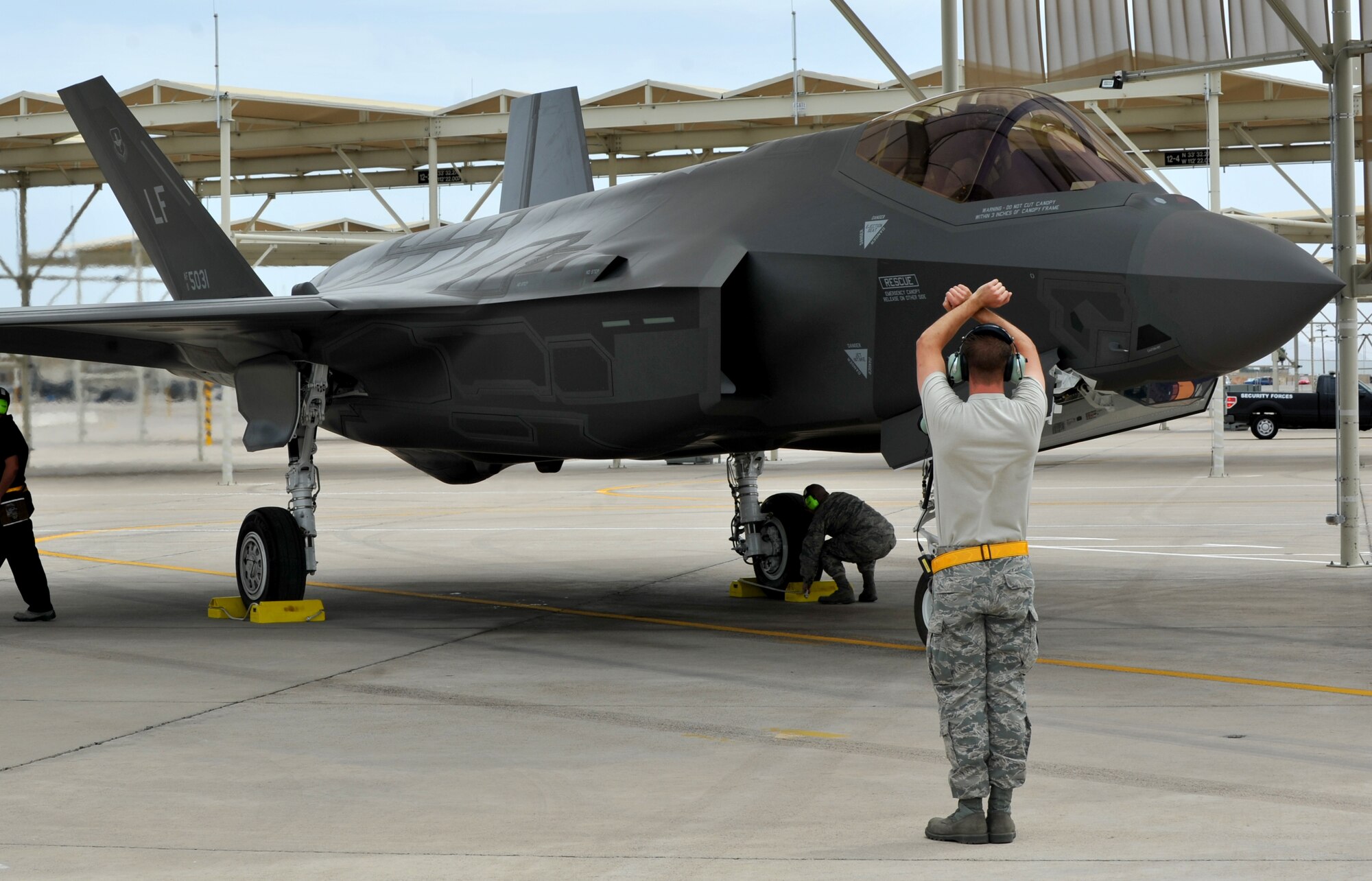 Senior Airman Paul Swanson, 61st Aircraft Maintenance Unit crew chief, marshals in one of Luke Air Force Base’s F-35 Lightning II after one of its first sorties May 6, 2014.  (U.S. Air Force photo by Senior Airman Jason Colbert)