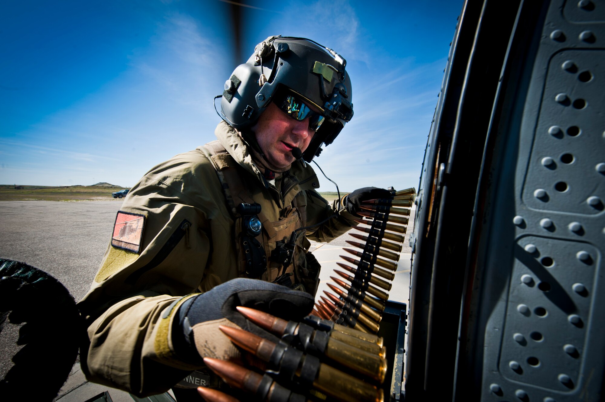 Tech. Sgt. Jeff Waldrup, 34th Weapons Squadron special mission aviator, loads ammunition to an HH-60 Pave Hawk during the terminal employment course, April 29, 2014, at Orchard Combat Training Center, Idaho.  The goal of the U.S. Air Force Weapons School course is to train students to be tactical experts in their combat specialty while also learning the art of battle-space dominance.  (U.S. Air Force Photo by Senior Airman Jason Couillard)