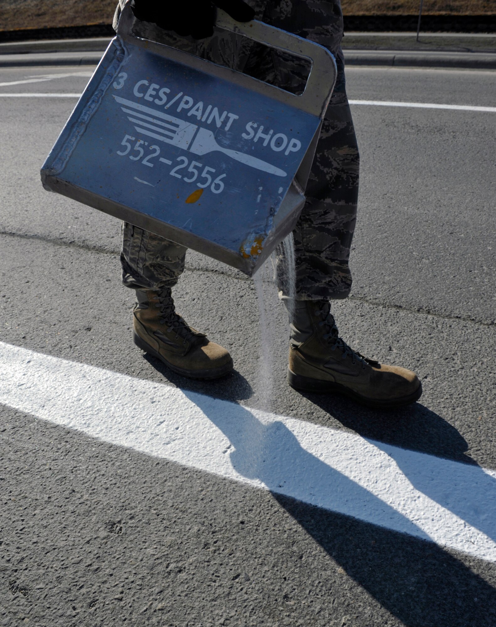 A 773d CES Airman pours glass beads on wet paint on Joint Base Elmendorf-Richardson, Alaska, April 30, 2014. The glass beads are used to reflect the light from motorists’ headlights at night to see the lines better. The lines on JBER are repainted every year due to the wear and tear from snow plows during the winter. (U.S. Air Force photo/Airman 1st Class Tammie Ramsouer)