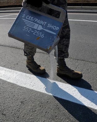 A 773d CES Airman pours glass beads on wet paint on Joint Base Elmendorf-Richardson, Alaska, April 30, 2014. The glass beads are used to reflect the light from motorists’ headlights at night to see the lines better. The lines on JBER are repainted every year due to the wear and tear from snow plows during the winter. (U.S. Air Force photo/Airman 1st Class Tammie Ramsouer)
