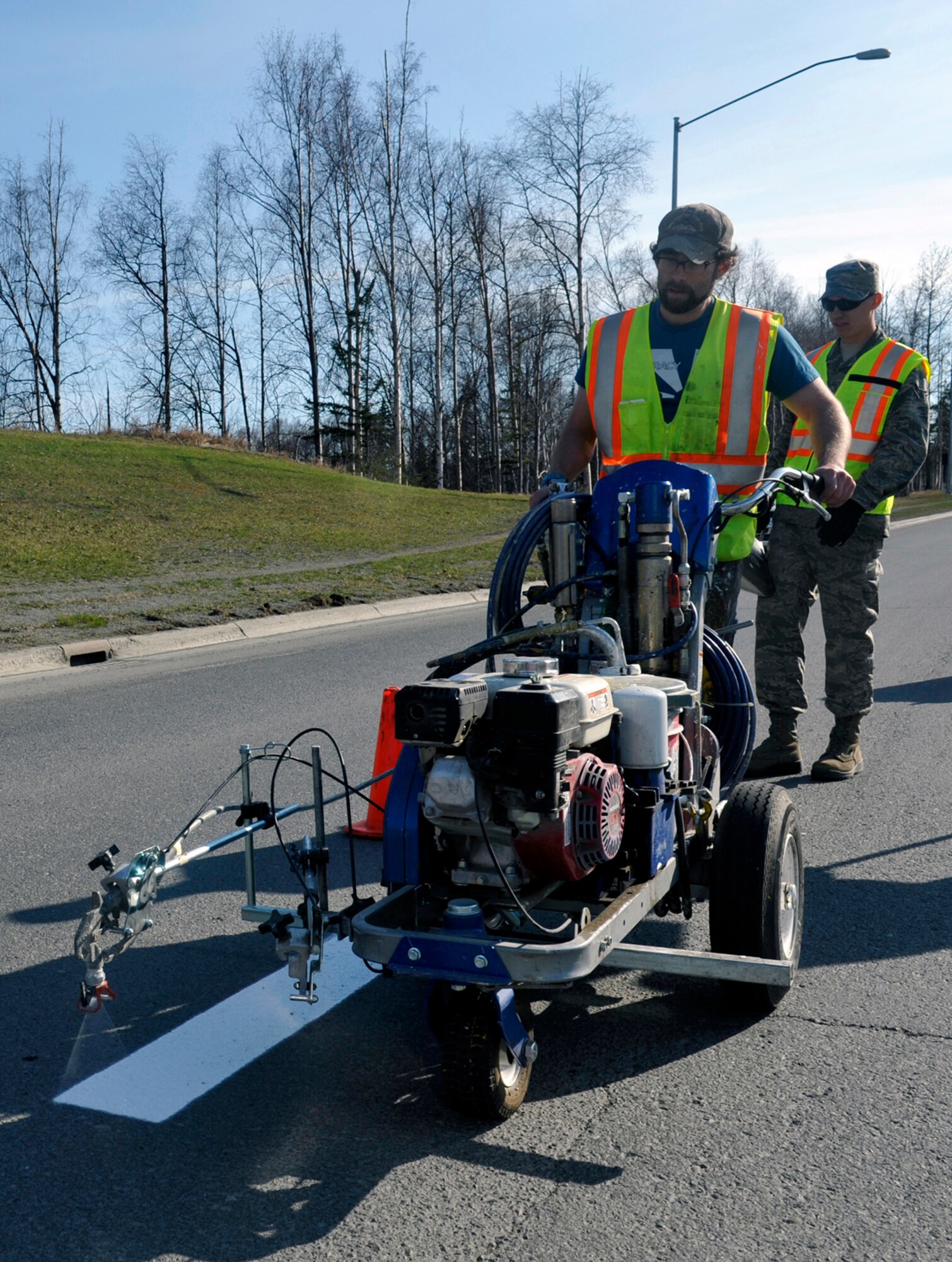 Matthew Carl Michaelis, 773d Civil Engineer Squadron sign painter, sprays lines with a striping machine on Joint Base Elmendorf-Richardson, Alaska, April 30, 2014. The lines on JBER are repainted yearly due to damage during the winter months. (U.S. Air Force photo/Airman 1st Class Tammie Ramsouer)
