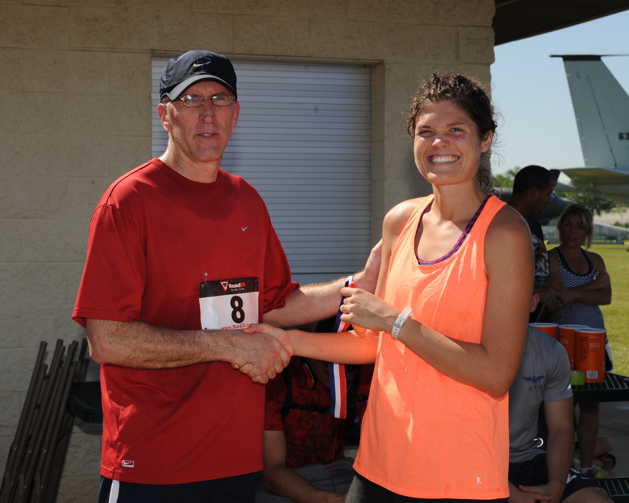 1st Lt. Katherine Ward, 608th Air Operations Center, right, receives the 1st place female medal from Maj. Gen. Scott Vander Hamm, Eighth Air Force commander, during the 3rd annual Mighty Eighth 8k run on Barksdale Air Force Base, La., May 3, 2014. The annual run began at the 2nd Security Forces Squadron, went through the Barksdale Global Power Museum airpark, base housing and ended back at the 2nd SFS building. (U.S. Air Force photo/Senior Airman Benjamin Gonsier)
