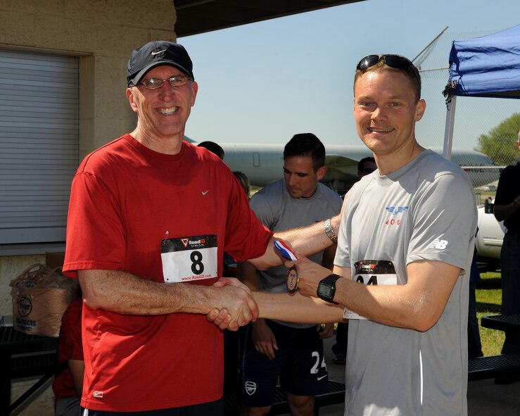 Capt. William Graff, 20th Bomb Squadron, right, receives the 1st place male medal from Maj. Gen. Scott Vander Hamm, Eighth Air Force commander, during the 3rd Annual Mighty Eighth 8k run on Barksdale Air Force Base, La., May 3, 2014. The annual run began at the 2nd Security Forces Squadron, went through the Barksdale Global Power Museum airpark, base housing and ended back at the 2nd SFS building. (U.S. Air Force photo/Senior Airman Benjamin Gonsier)