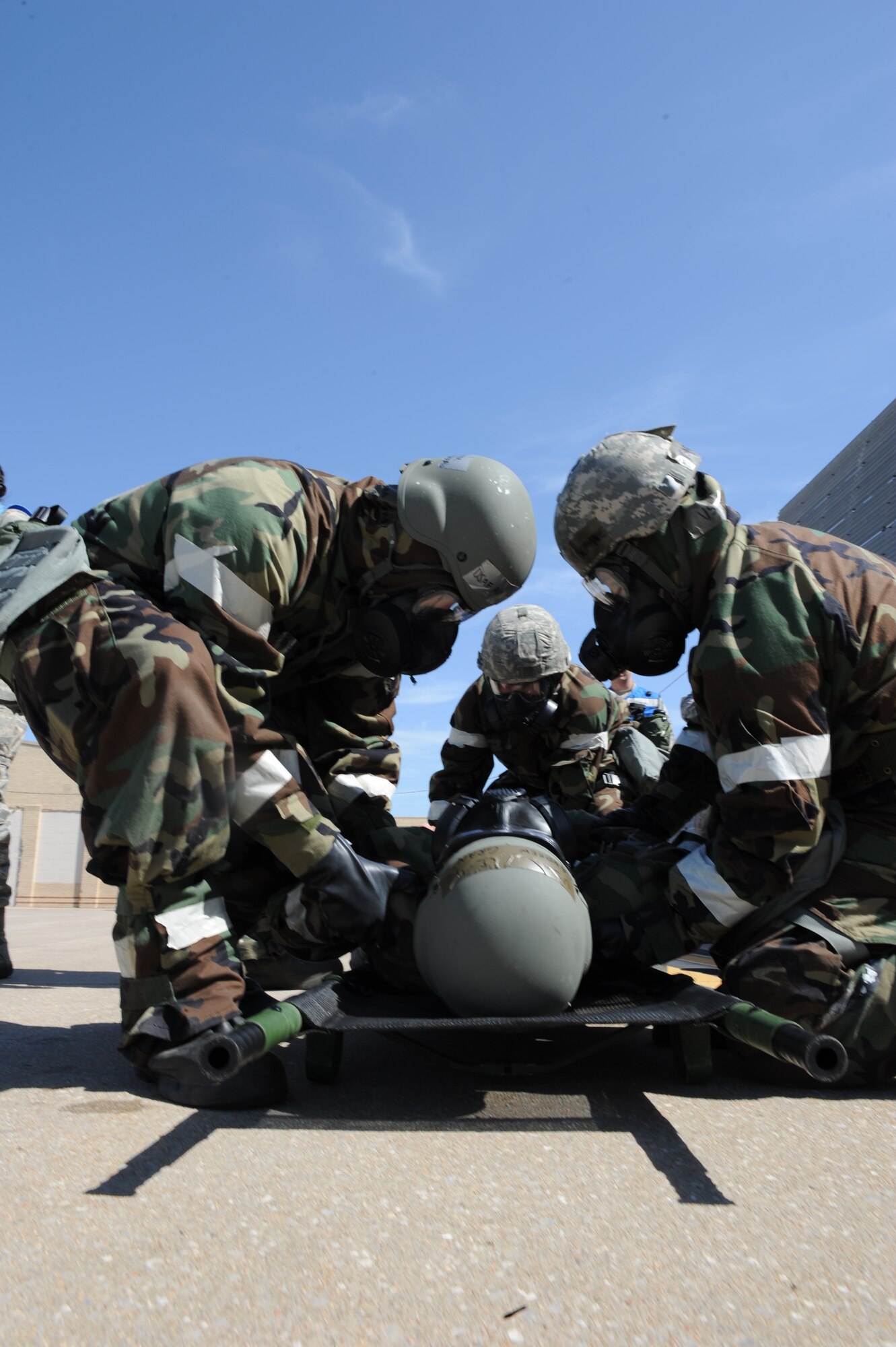 Airmen assist a simulated wounded wingman onto a litter during training, May 6, 2014, at McConnell Air Force Base, Kan. This kind of training is designed to prepare Airmen for possible combat scenarios. (U.S. Air Force photo/Airman 1st Class Aaron-Forrest Wainwright) 