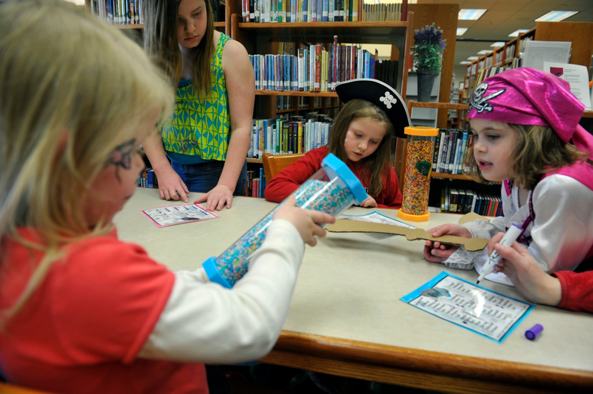 Children look for hidden objects in a puzzle game during the annual Princess and Pirates Ball on Joint Base Elmendorf-Richardson, Alaska, May 2, 2014. Volunteers handed props to children as they entered the library, and included scimitars and wands, which were all made from recycled materials, such as cardboard and construction paper. (U.S. Air Force photo/Airman 1st Class Tammie Ramsouer)