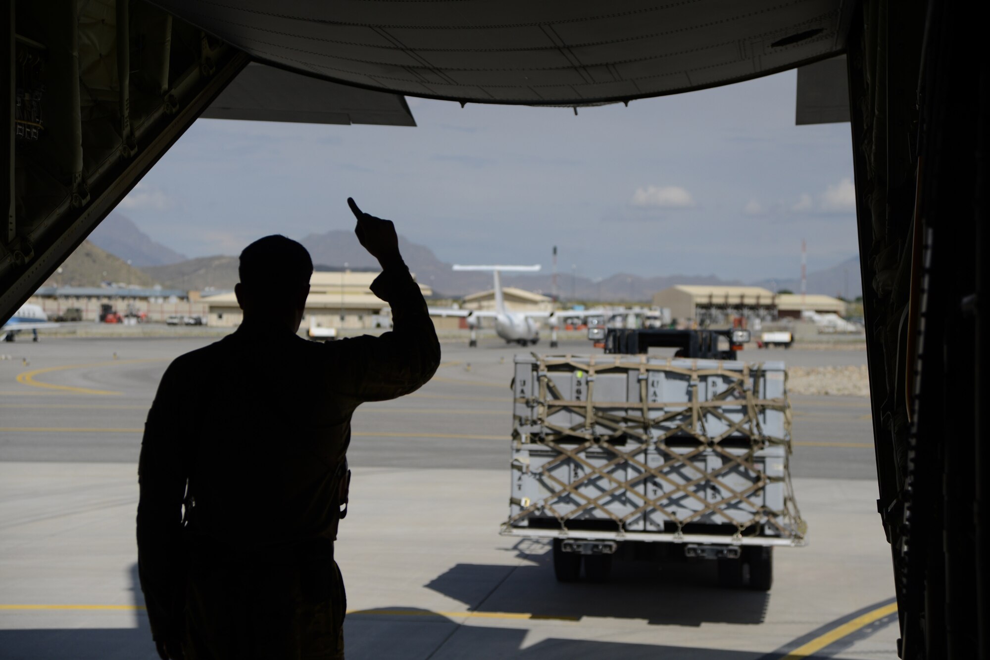 KABUL INTERNATIONAL AIRPORT, Afghanistan - U.S. Air Force Tech. Sgt. Thomas Baker, a loadmaster assigned to the 774th Expeditionary Airlift Squadron, 455th Air Expeditionary Wing signals a forklift driver as supplies are loaded onto a C-130 J-30 at Kabul International Airport May 5, 2014. Coalition Forces joined together to assist the Afghan Government with relief efforts after a recent mudslide in Badakhshan province. (U.S. Air Force photo by Master Sgt. Cohen A. Young)