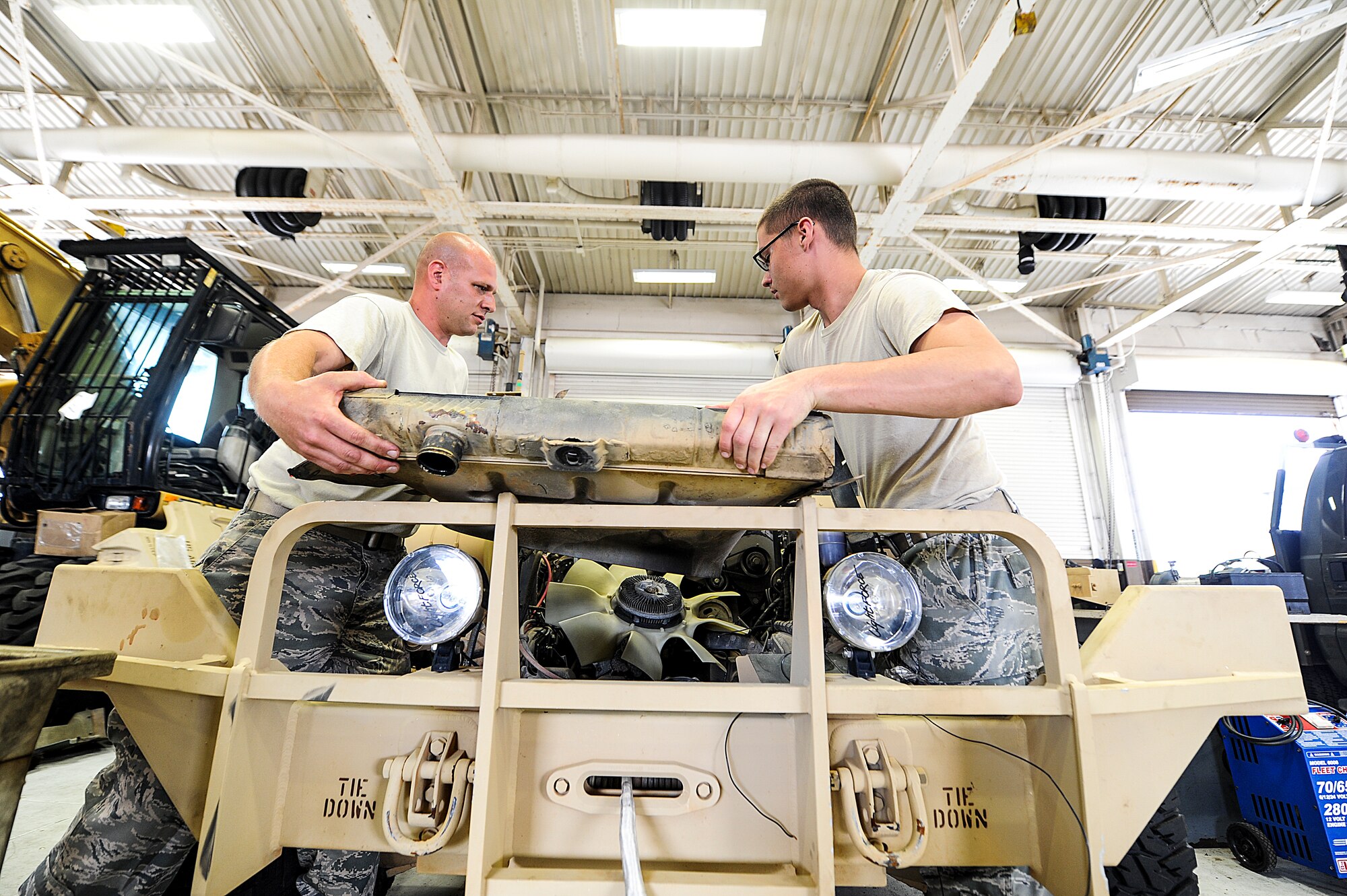 Vehicle maintainters from the 1st Special Operations Logistics Readiness Squadron lift a radiator out of a Humvee at Hurlburt Field, Fla., April 28, 2014.  The vehicle maintenance flight keeps their vehicles serviceable at all times. (U.S. Air Force photo/Senior Airman Christopher Callaway)  