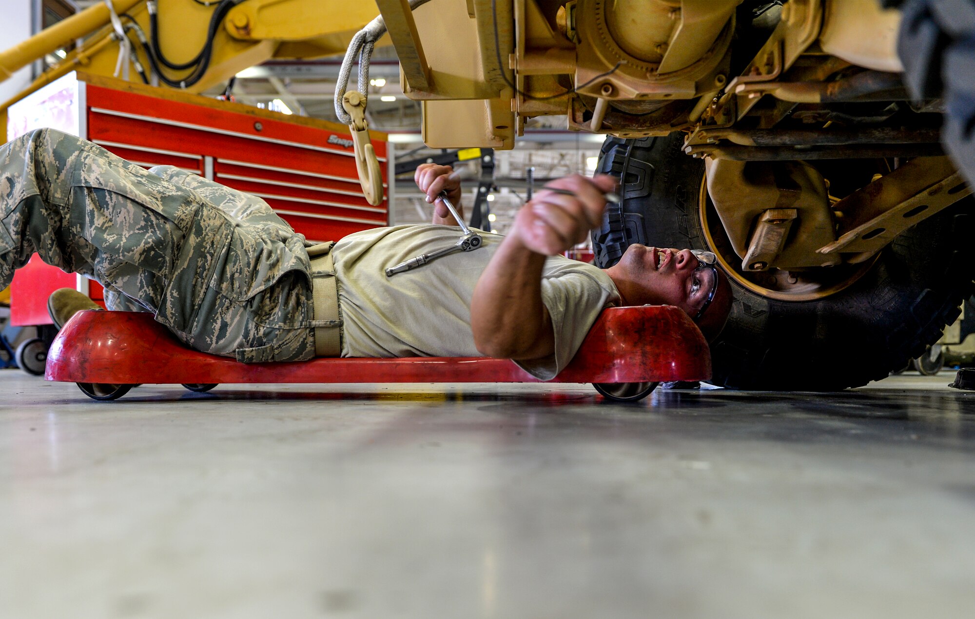 Staff Sgt. Matthew Di Terlizzi, 1st Special Operations Logistics Readiness Squadron vehicle maintenance specialist, slides under a Humvee to perform maintenance at Hurlburt Field, Fla., April 28, 2014. Di Terlizzi removed the radiator and fixed minor issues with the vehicle. (U.S. Air Force photo/Senior Airman Christopher Callaway) 