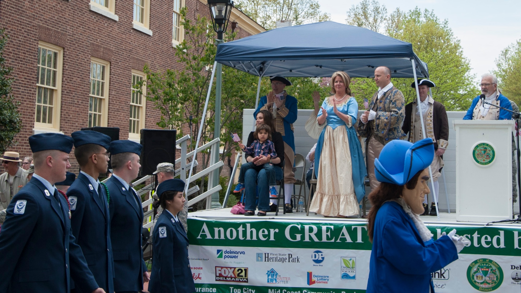 Dover High School Air Force Junior Reserve Officers' Training Corps walk past the stage as Col. Randy Huiss, 436th Airlift Wing vice commander, Col. Jonathan Philebaum, 512th Operations Group commander and Delaware Gov. Jack Markell look on, during the Dover Days parade May 3, 2014, in downtown Dover, Del. The 81st annual Dover Days parade showcased the many facets of Dover from the past to the present. (U.S. Air Force photo/Senior Airman Jared Duhon)