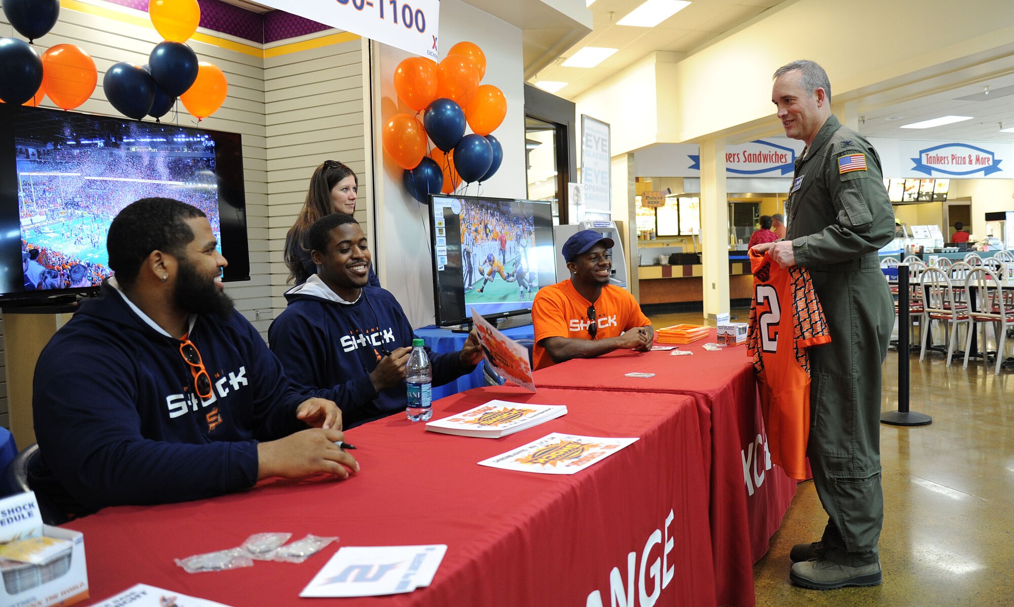 Col. Brian Newberry speaks with Spokane Shock arena football players as they sign posters during the meet and greet at Fairchild Air Force Base, Wash., May 2, 2014. Shock football players and staff members toured the Survival, Evasion, Resistance and Escape and Exchange for a meet and greet. Newberry is the 92nd Air Refueling Wing commander. (U.S. Air Force photo by Airman 1st Class Janelle Patiño/Released)