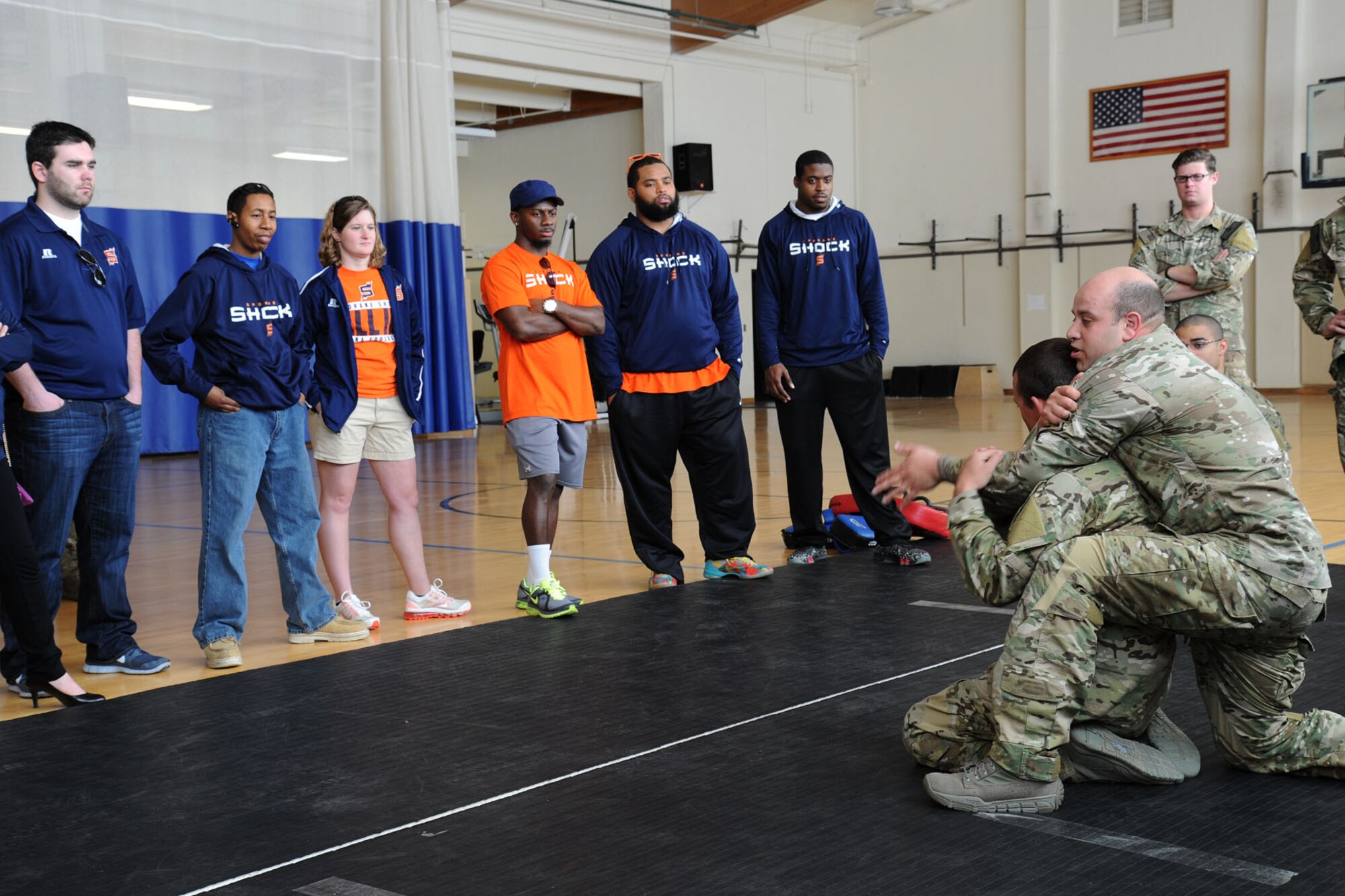 Senior Airman Anthony Fischer demonstrates combative maneuvers to Spokane Shock arena football players and staff members during a base tour at Fairchild Air Force Base, Wash., May 2, 2014. Shock football players and staff members toured the Survival, Evasion, Resistance and Escape and Exchange for a meet and greet. (U.S. Air Force photo by Airman 1st Class Janelle Patiño/Released)