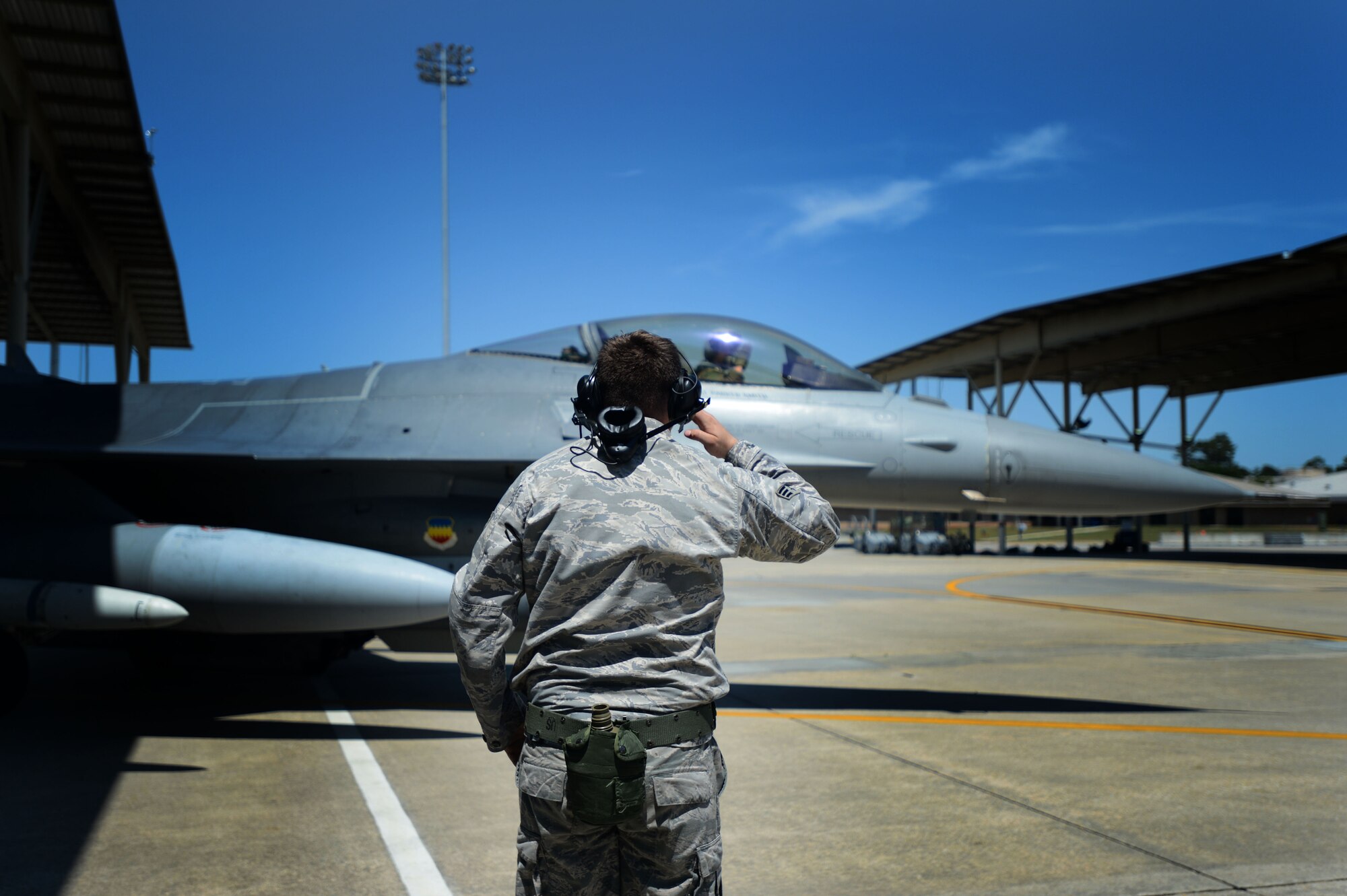 U.S. Air Force Senior Airman Ethan Edmisten, 20th Aircraft Maintenance Squadron assistant dedicated tactical aircraft maintainer assigned to the 55th Aircraft Maintenance Unit, renders a salute as a pilot taxis out of a sun shade during Operational Readiness Exercise Weasel Victory 14-06 at Shaw Air Force Base, S.C., May 5, 2014. Edmisten spent more than an hour prepping the F-16CJ Fighting Falcon ensuring the jet was prepared to fly. (U.S. Air Force photo by Airman 1st Class Jensen Stidham/Released)