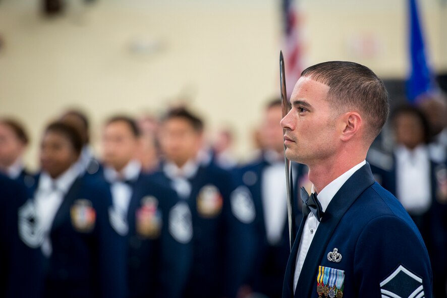 U.S. Air Force Master Sgt. Michael Cherry, 23d Civil Engineer Squadron and ceremonial sergeant at arms, stands at attention for the presentation of the colors during a dining-in at Moody Air Force Base, Ga., May 2, 2014. The sergeant at arms carries a sword symbolizing protection, power and strength. (U.S. Air Force photo by Airman 1st Class Ryan Callaghan/Released)