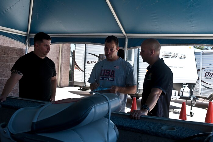 Carlos Del Valle, right, 99th Force Support Squadron outdoor recreation trip program director, assists Lupe Asta and Tech. Sgt. Luis Martinez, 57th Aircraft Maintenance Squadron crew chief, with renting a boat from outdoor recreations May 2, 2014, at Nellis Air Force Base, Nev.  Outdoor Recreations just received new equipment to include two EVO 19.5 foot travel trailers, a Swift travel trailer, fishing and pontoon boat, five hybrid bikes and two utility trailers. (U.S. Air Force photo by Senior Airman Matthew Lancaster)