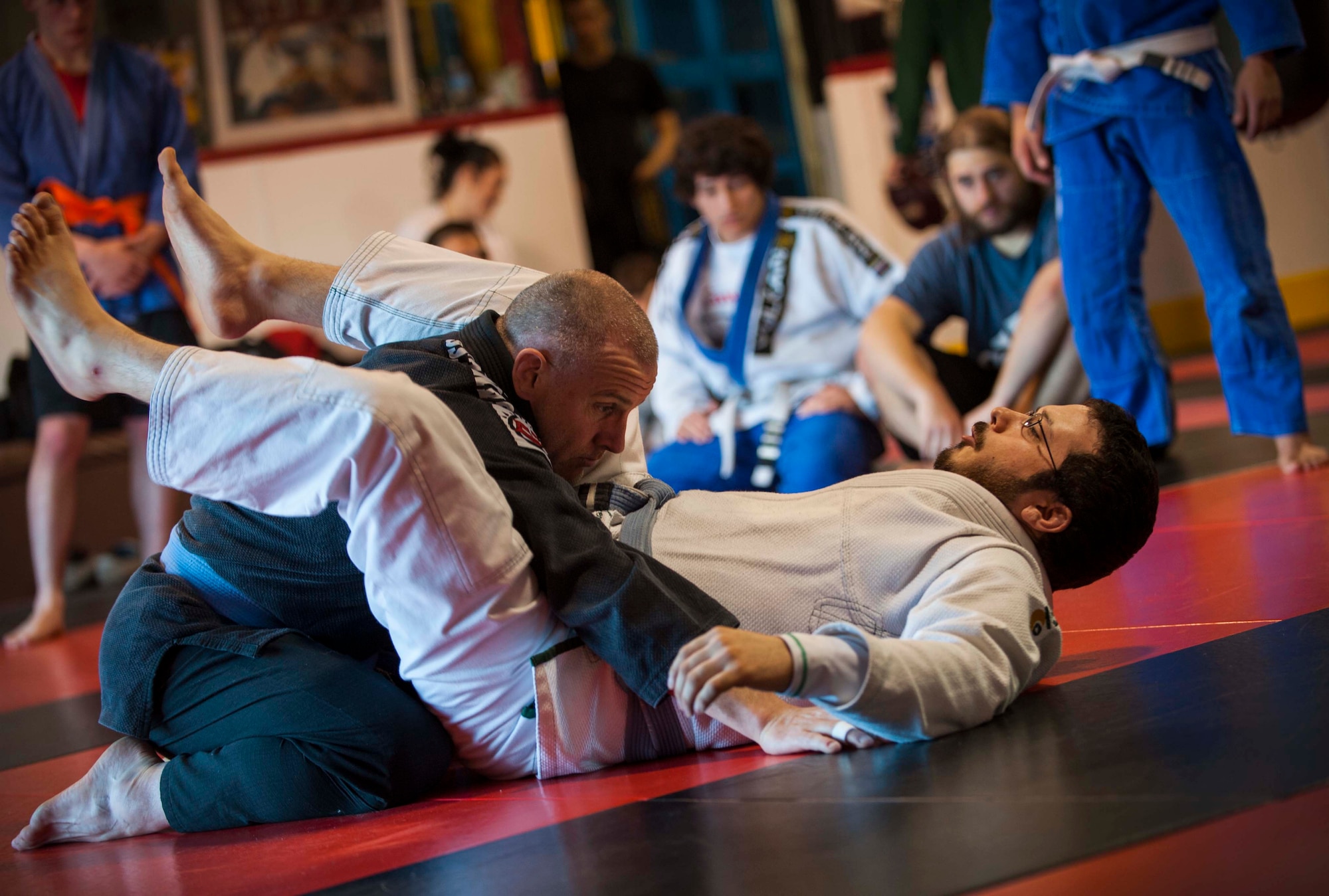 Two members of the Minot Brazilian Jiu-Jitsu team demonstrate techniques to fellow team members at Calavera Martial Arts and Boxing club in Minot, N.D., April 21, 2014. Eight members of the team will compete in a national tournament in May. (U.S. Air Force photo/Airman 1st Class Apryl Hall)
