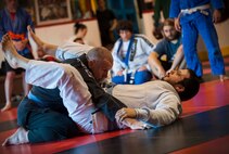 Two members of the Minot Brazilian Jiu-Jitsu team demonstrate techniques to fellow team members at Calavera Martial Arts and Boxing club in Minot, N.D., April 21, 2014. Eight members of the team will compete in a national tournament in May. (U.S. Air Force photo/Airman 1st Class Apryl Hall)