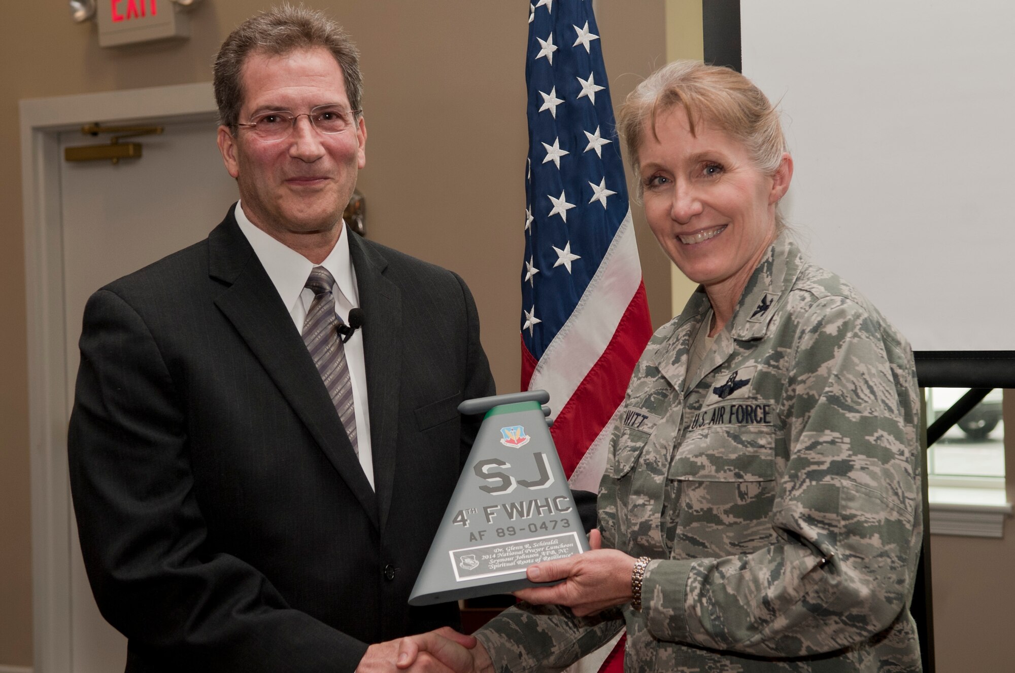 Dr. Glenn Schiraldi, University of Maryland School of Public Health psychology professor and guest speaker, left, is presented a placard by Col. Jeannie Leavitt, 4th Fighter Wing commander, during the National Prayer luncheon, May 2, 2014, at Seymour Johnson Air Force Base, N.C. Schiraldi spoke to members of Team Seymour about spiritual resilience. (U.S. Air Force photo/Airman 1st Class Shawna L. Keyes) 