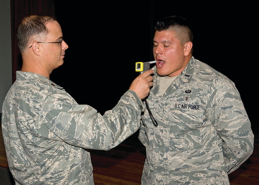 Maj Patrick Bass, 7th Security Forces Squadron,
administers a breathalizer test to 1Lt Ezekial Duran, 7th Aerospace
Medicine Squadron, after a briefing on distracted driving during a
Critical Days of Summer commander’s call at Dyess AFB, Texas.