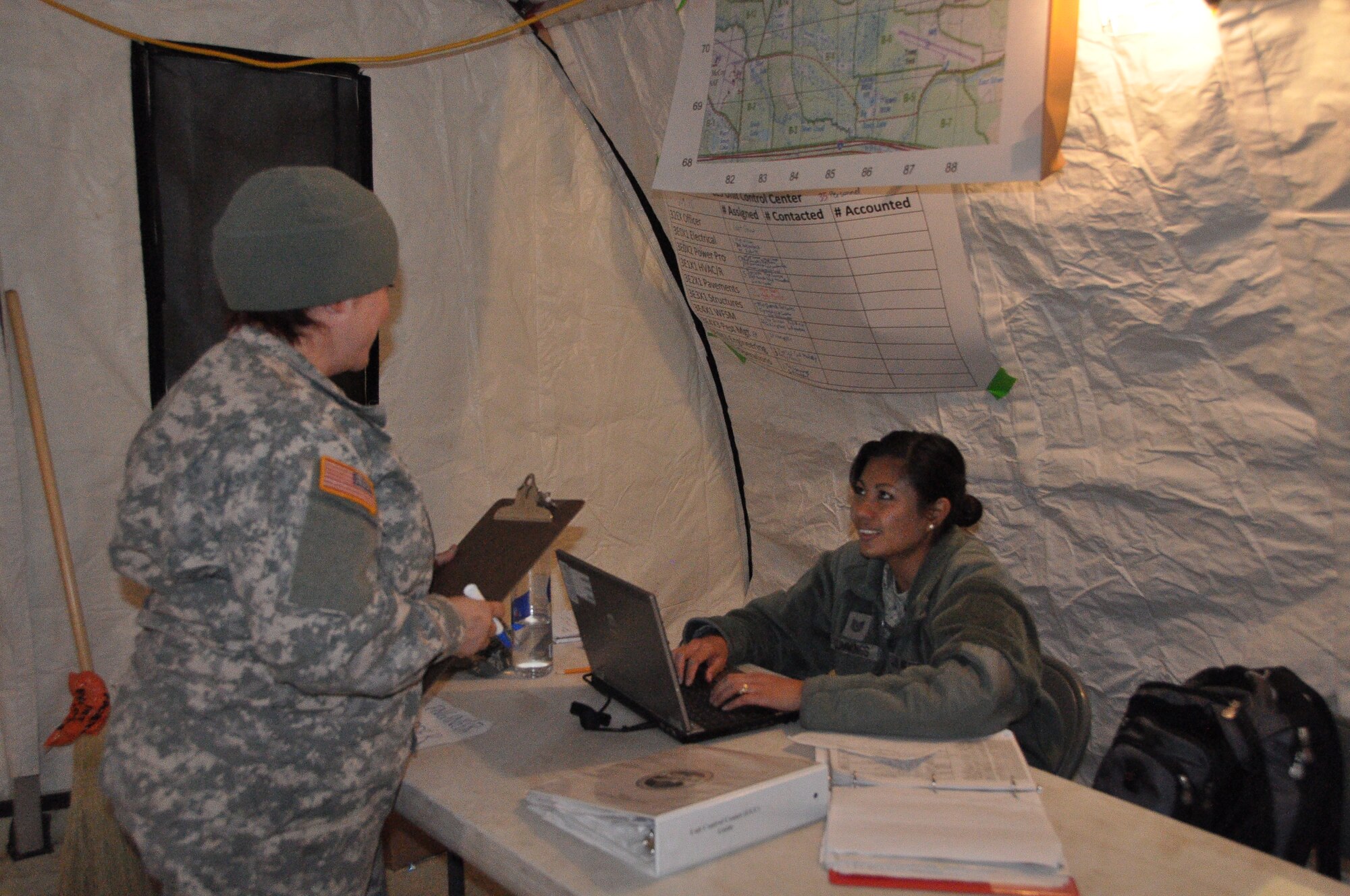 Tech. Sgt. Jane Cummings, a 433rd Civil Engineer Operations specialist, helps Private 1st Class Anna Santiago with a work order in the Unit Control Center at Fort McCoy, Wisconsin in support of Exercise Patriot Warrior May 3. The 433rd CE unit out of Joint Base San Antonio-Lackland arrived here April 26 to bed down a Forward Operating Base, and have moved into the sustainment phase. (U.S. Air Force photo by 1st Lt. Denise Haeussler)