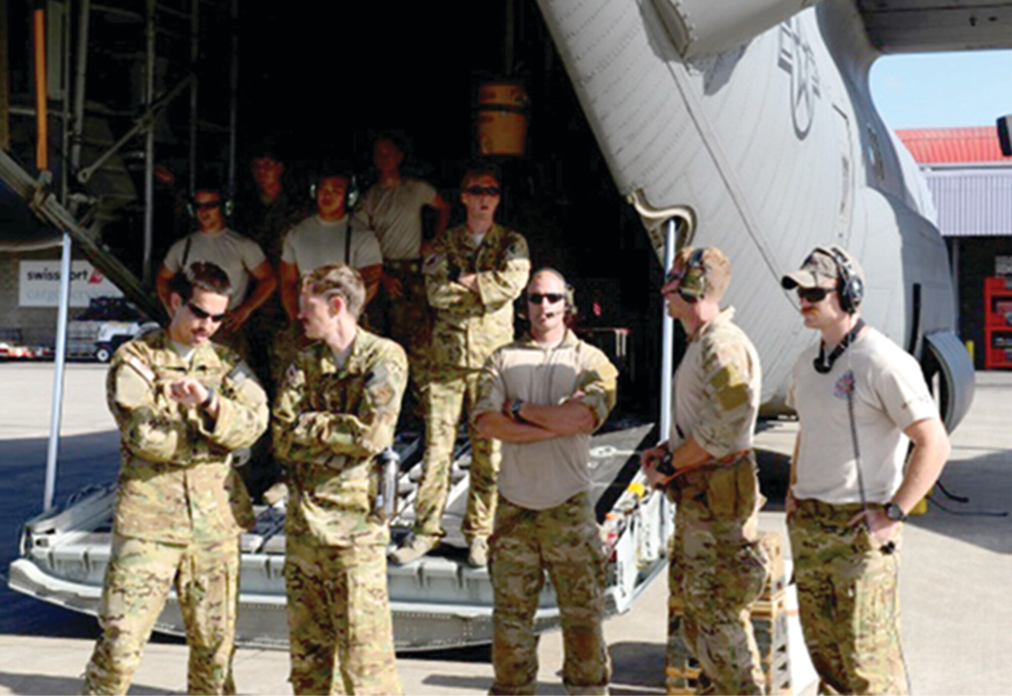 The entire crew (maintenance, aircrew, and PJ’s) of Rogue 52 observe the processing of evacuees by embassy personnel on the ramp in Nairobi, Kenya, after their successful exfiltration from Juba, the capital of South Sudan.