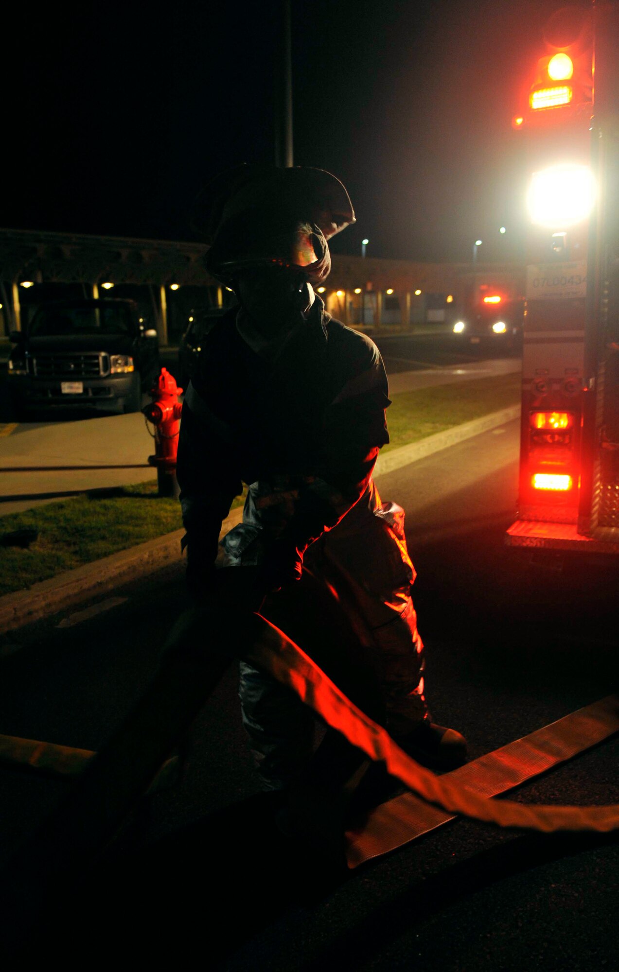 Senior Airman John Duncan, 51st Civil Engineer Squadron fire fighter, straightens the hose to put onto the fire truck May 6 after completing a simulated missile attack scenario at the base passenger terminal on Osan Air Base, Republic of Korea. The scenario caused a fire in the building and turned into a mass casualty event. (U.S. Air Force photo by Senior Airman David Owsianka)