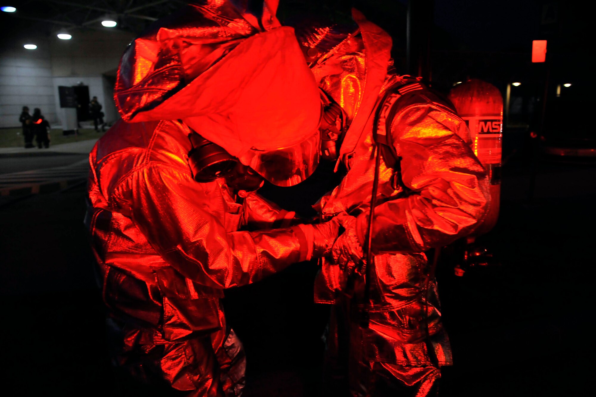 Firefighters perform a gear check after arriving on scene May 6 during a simulated missile attack scenario at the base passenger terminal on Osan Air Base, Republic of Korea. The scenario caused a fire in the building and turned into a mass casualty event. (U.S. Air Force photo by Senior Airman David Owsianka)