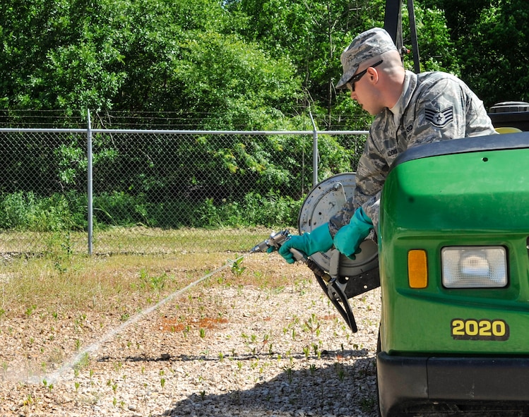 Staff Sgt. Scott Addis, 2nd Civil Engineer Squadron pest management journeyman, sprays herbicide on Barksdale Air Force Base, May 2, 2014. No plants, weeds or foliage is permitted to grow near certain buildings, towers or equipment, so herbicide is sprayed to reduce the growth. (U.S. Air Force Photo/Airman 1st Class Benjamin Raughton)